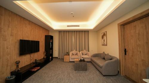 a living room with a couch and a tv at بنزرت للشقق المخدومة in Al Hofuf
