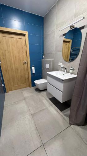a bathroom with a toilet and a sink and a mirror at 4 winds Boreos 2 in Palanga