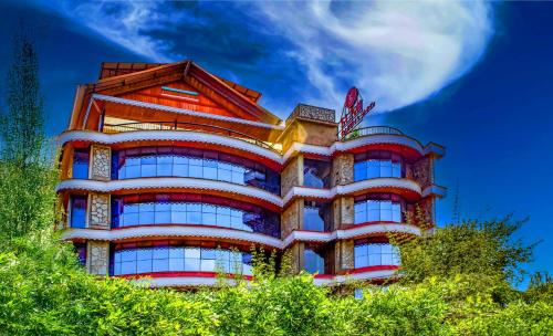 a tall building with trees in front of it at Sumitel Queens Yard in Darjeeling