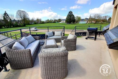 four wicker chairs and couches on a patio at Le petit duc in Langast