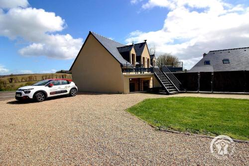 a white car parked in front of a house at Le petit duc in Langast