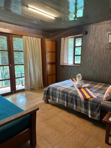 a bedroom with a bed and a table and windows at Ina Homestay in Coron