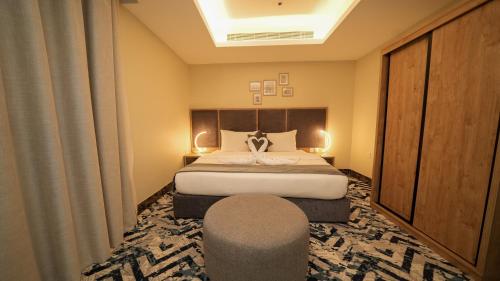 a hotel room with a bed and a chair at بنزرت للشقق المخدومة in Al Hofuf