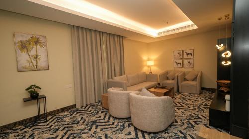 a living room with a couch and chairs in a room at بنزرت للشقق المخدومة in Al Hofuf