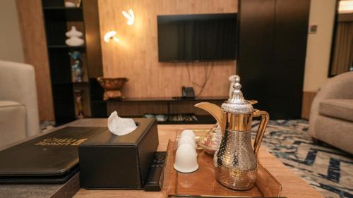 a tea kettle on a table in a living room at بنزرت للشقق المخدومة in Al Hofuf