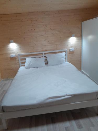 a bed with white sheets and pillows in a room at La Cabana in Vechea