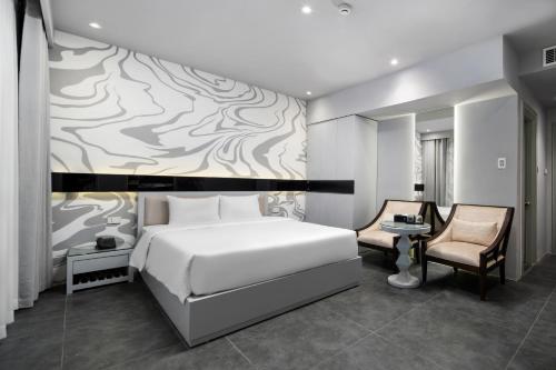 a bedroom with a white bed and a wall mural at J Village Hotel - Triệu Việt Vương in Hanoi
