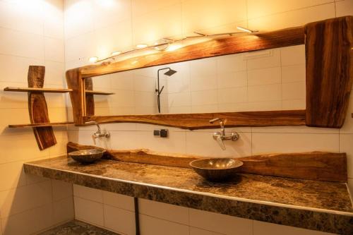 a bathroom with two sinks and a mirror at Villa Saloum decouvertes in Ndangane