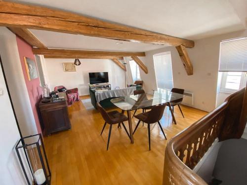 Colmar Attic Duplex في كولمار: غرفة طعام مع طاولة وكراسي زجاجية
