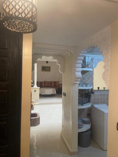 una cucina con una camera con un letto sullo sfondo di Riad Al-Bushra a Marrakech