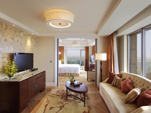 a living room with a couch and a television at Fairmont Yangcheng Lake in Kunshan