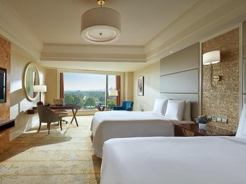 a hotel room with two beds and a desk at Fairmont Yangcheng Lake in Kunshan