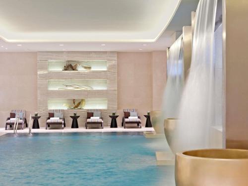 a hotel lobby with a swimming pool and a table and chairs at Fairmont Yangcheng Lake in Kunshan