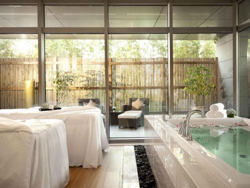 a large room with a bath tub and a table at Fairmont Yangcheng Lake in Kunshan