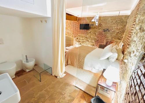een slaapkamer met een bakstenen muur, een bed en een wastafel bij Super Galleria in Tuscania