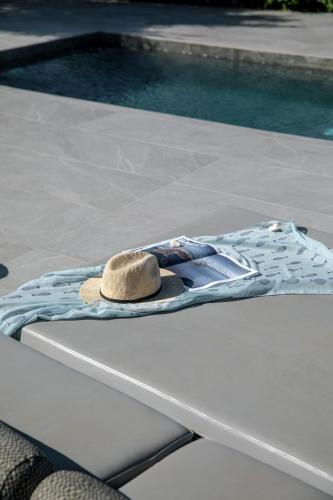 a hat sitting on a table next to a pool at Melidonia Suites in Akrotiri