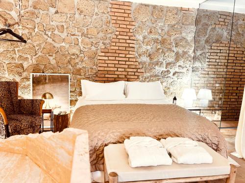 een slaapkamer met een groot bed en een bakstenen muur bij Super Galleria in Tuscania