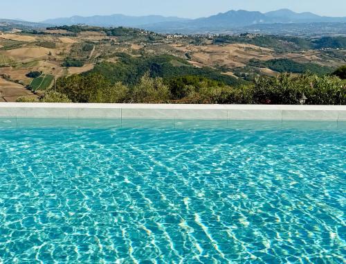 a swimming pool with blue water and a view at HURZ - giardino sannita in Pietrelcina
