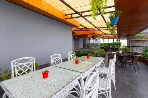 an outdoor patio with tables and chairs and plants at Sumitel Queens Yard in Darjeeling