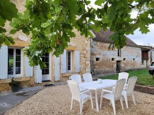 ein weißer Tisch und Stühle vor einem Gebäude in der Unterkunft Lake House A Tranquil Escape in Lescuretie