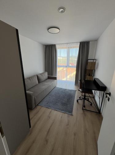 a living room with a couch and a piano at Aurum Apartman Harmónia a komfort v centre Bardejova in Bardejov
