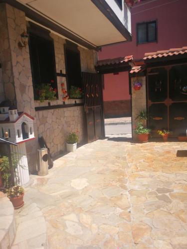 a building with a courtyard with a door and a patio at Hotel St. George Pobedonosets in Bansko