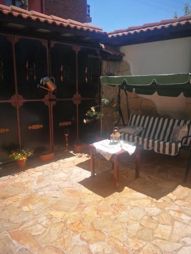 a patio with a bench and a table with a doll on it at Hotel St. George Pobedonosets in Bansko
