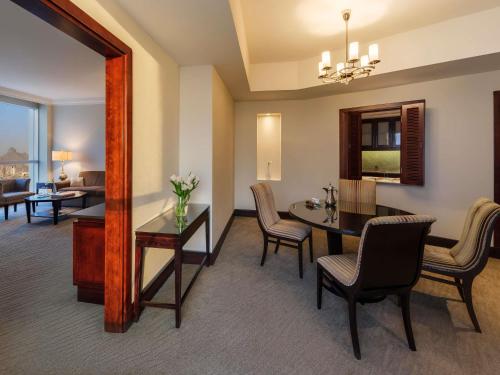 a dining room and living room with a table and chairs at Makkah Clock Royal Tower, A Fairmont Hotel in Makkah