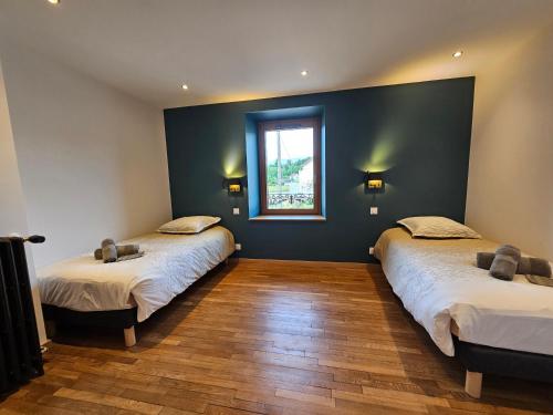 two beds in a room with a window at L'Escargot - Maison avec espace bien être in Vagney