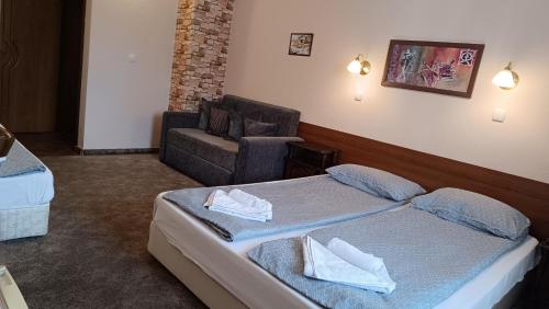 a hotel room with a bed and a chair at Hotel St. George Pobedonosets in Bansko