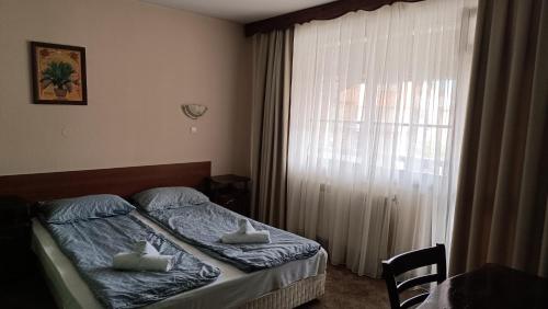 a bedroom with a bed with two towels on it at Hotel St. George Pobedonosets in Bansko