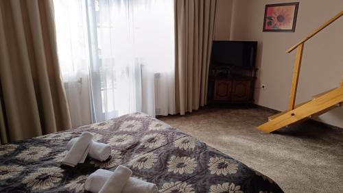 a bedroom with a bed with towels on it at Hotel St. George Pobedonosets in Bansko