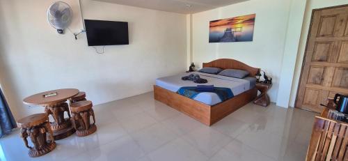 a bedroom with a bed and a tv on the wall at Palika Sun House in Amphoe Koh Samui