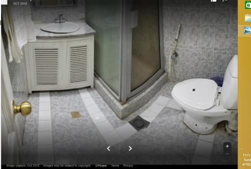 a bathroom with a shower and a toilet and a sink at Rupal Inn in Dargai