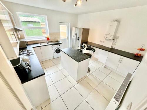 a kitchen with white appliances and a black counter top at Spencer Street Retreat in Northampton in Northampton