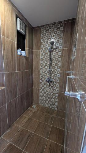 a bathroom with a shower with a glass door at Mulla Apartments in Malindi