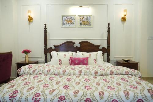 斋浦尔Royal Saket的一间卧室配有一张带枕头和床罩的大床