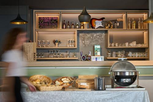 a woman walking past a counter in a bakery at ibis Chur in Chur