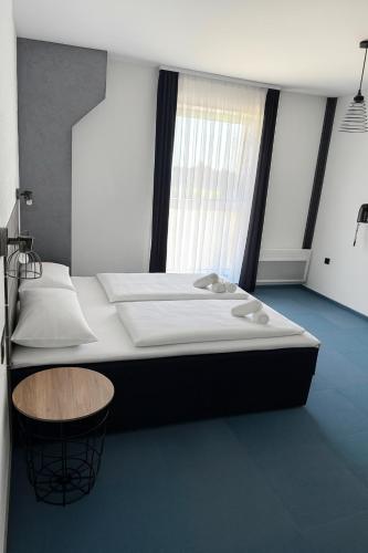 a bedroom with a large bed with a wooden stool at Arena Bakarni in Brčko
