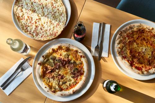 two pizzas sitting on top of a wooden table at ibis Chur in Chur