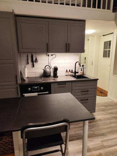 a kitchen with a black counter top and a table at PaprikanTiny House in Uppsala