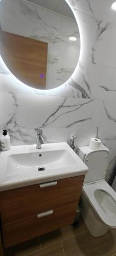 a bathroom with a sink and a toilet and a mirror at Exquisite Flat in Martorell (Barcelona) in Martorell