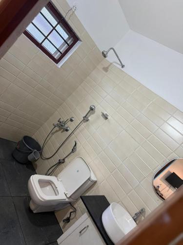 a bathroom with a toilet and a sink at Bliss stays in Cochin