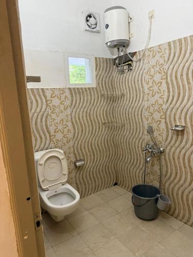 a small bathroom with a toilet and a window at Bliss stays in Cochin