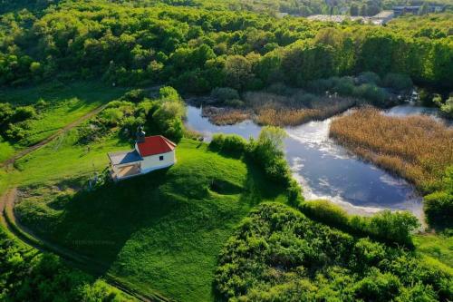 an aerial view of a house on a field next to a river at Tekeres-patak Fogadó in Pálosvörösmart