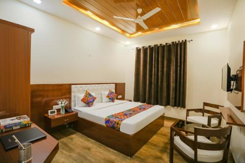 a bedroom with a bed and a table and a desk at FabExpress Trijal Inn in Lucknow