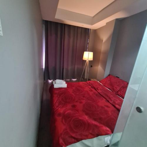 a bedroom with a red bed with a red sheet and roses at Driti Central Hotel in Tirana