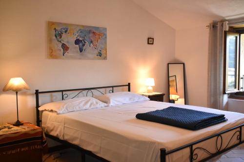 a bedroom with a large bed with white sheets at Corte L'Ovo - Country House 15 minutes from the heart of Verona in Grezzana