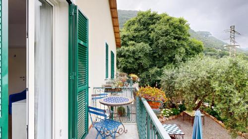 a balcony with a table and chairs and trees at Ai Cinque Campanili in Finale Ligure