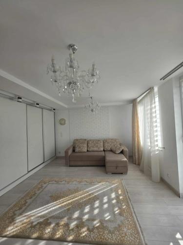 a living room with a couch and a chandelier at Apartament Klonowa in Kraśnik